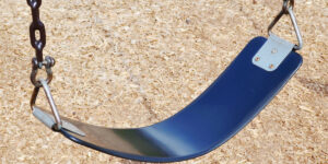 upclose shot of a blue seat to a playground swing