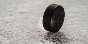 closeup of black hockey puck on ice