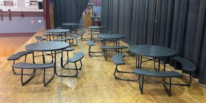 a group of dark green outdoor picnic tables