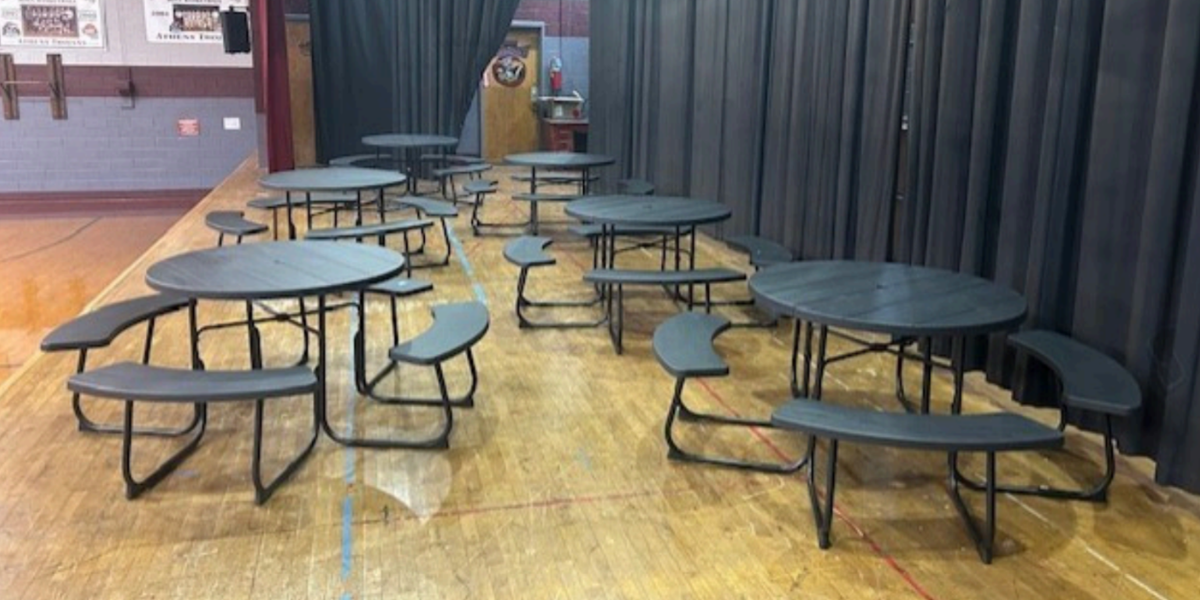 a group of dark green outdoor picnic tables