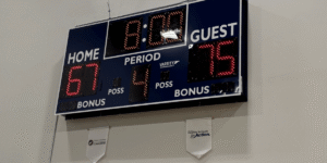 an electronic scoreboard hanging on gym wall