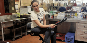 cafeteria lady on an exercise bike in the kitchen of the school