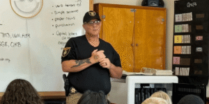 an officer giving a safety lecture in a classroom to kids
