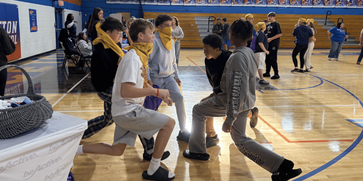 Princeton Middle School students wearing yellow bandanas participate in a group physical activity during the Mental Health and Wellness Fair.
